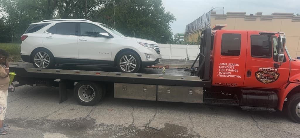 Ritchie Express Towing flatbed truck loaded with a white Chevrolet Equinox